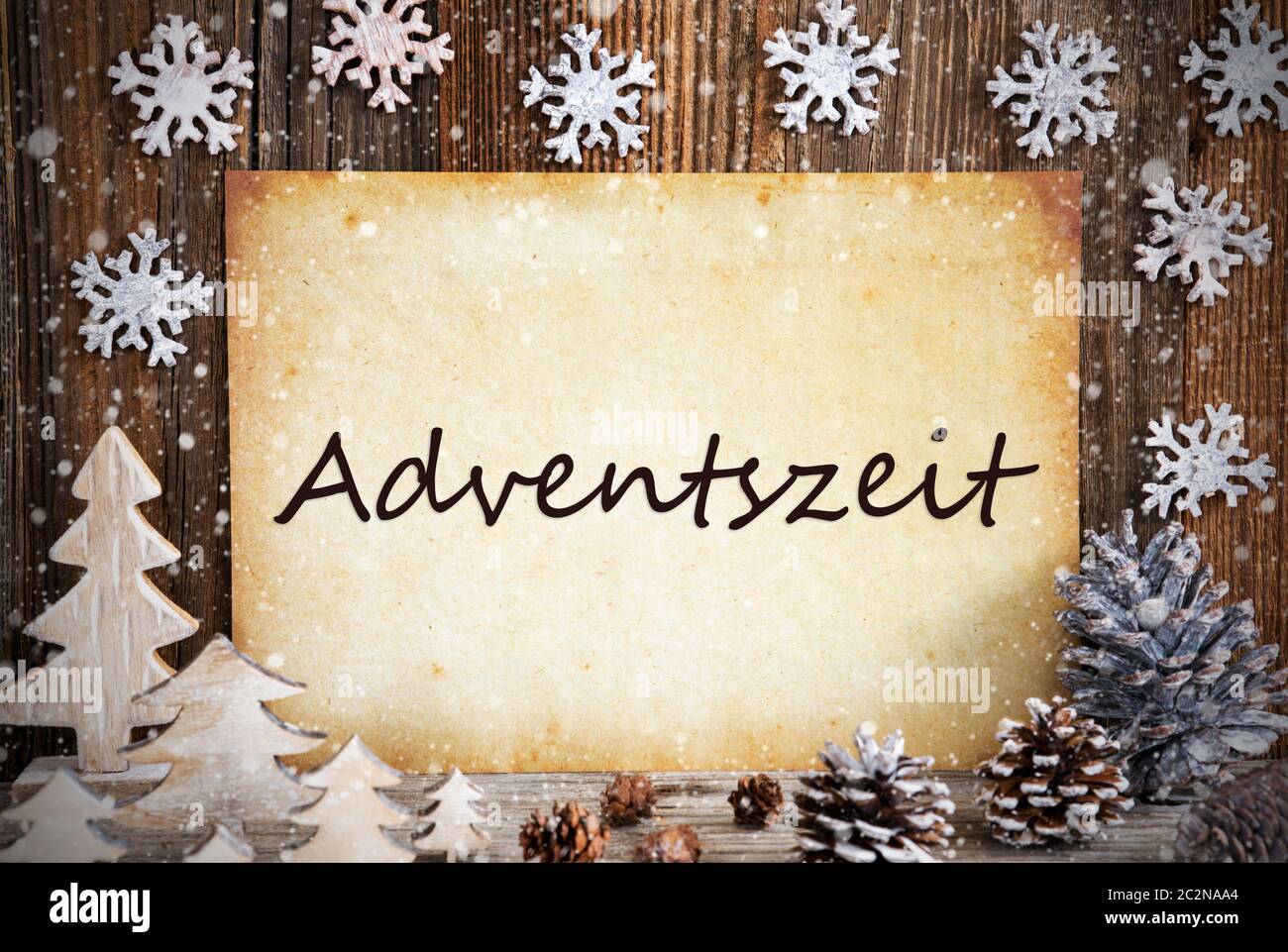 Altes Papier mit deutschem Text bedeutet Adventszeit Adventszeit. Weihnachtsdekoration wie Baum, Tannenzapfen und Schnee. Braun Holz- Hintergrund Stockfoto