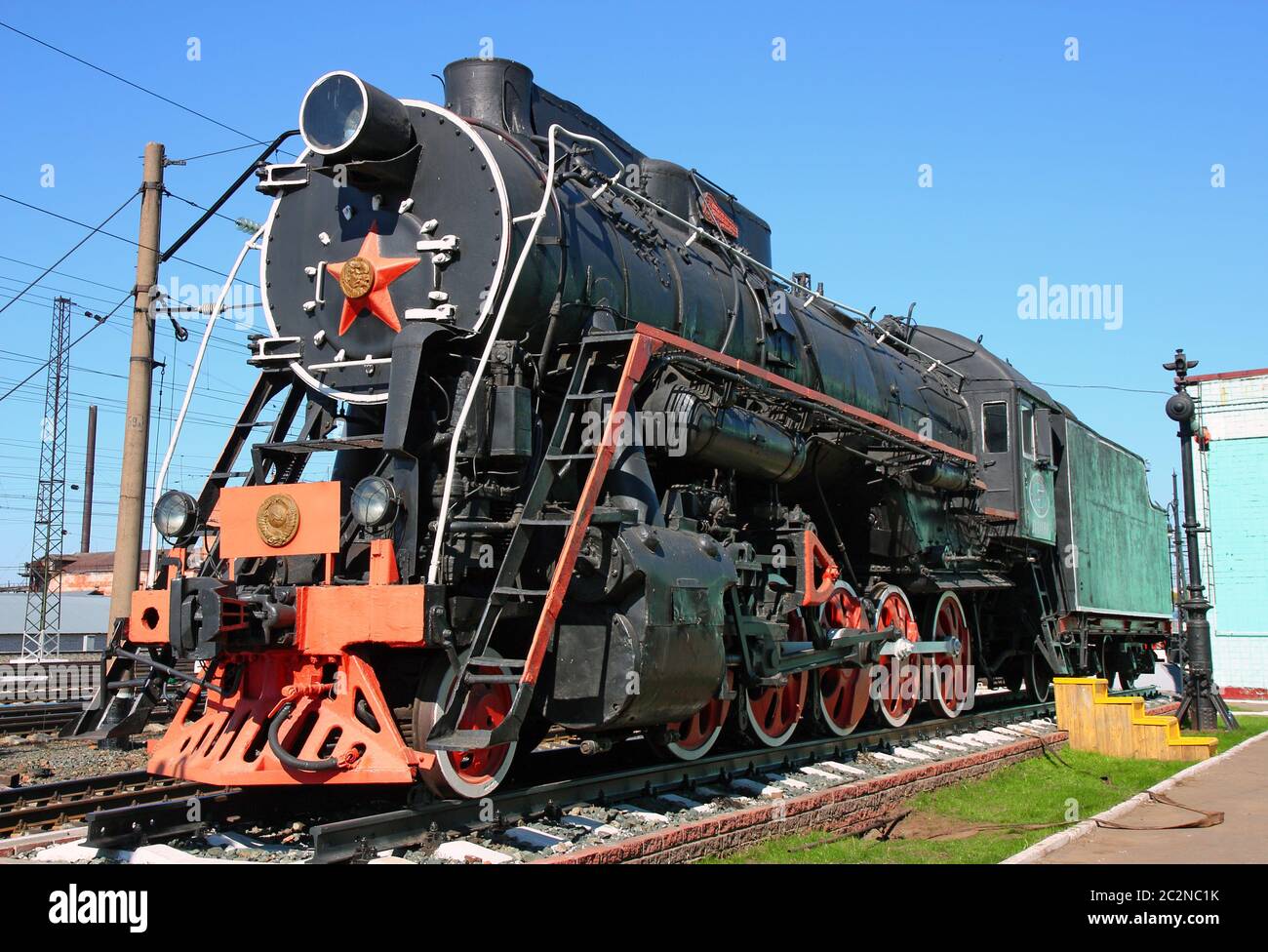 Alte schwarze Lokomotive im Bahnbetriebswerk auf dem Parkplatz Stockfoto