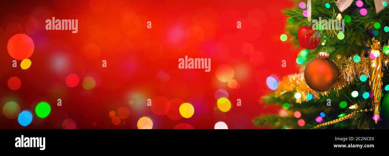 Weihnachtsbaum auf rotem Hintergrund mit bunten Bokeh-Lichtern Stockfoto