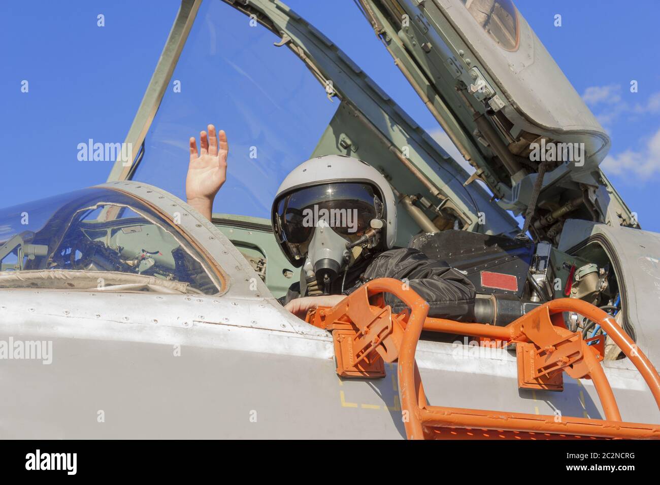 Militärischer Pilot im Cockpit Jet Flugzeug mit erhobener hand Stockfoto