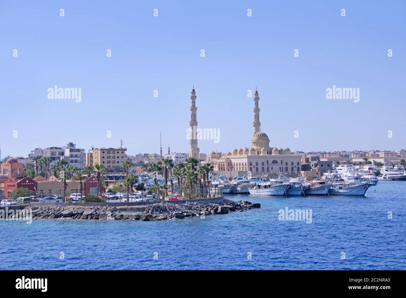 Blick auf den Damm von Hurghada mit festgeschobenen Yachten, Schiffen und einer schönen Moschee. Moderne ägyptische Stadt Stockfoto