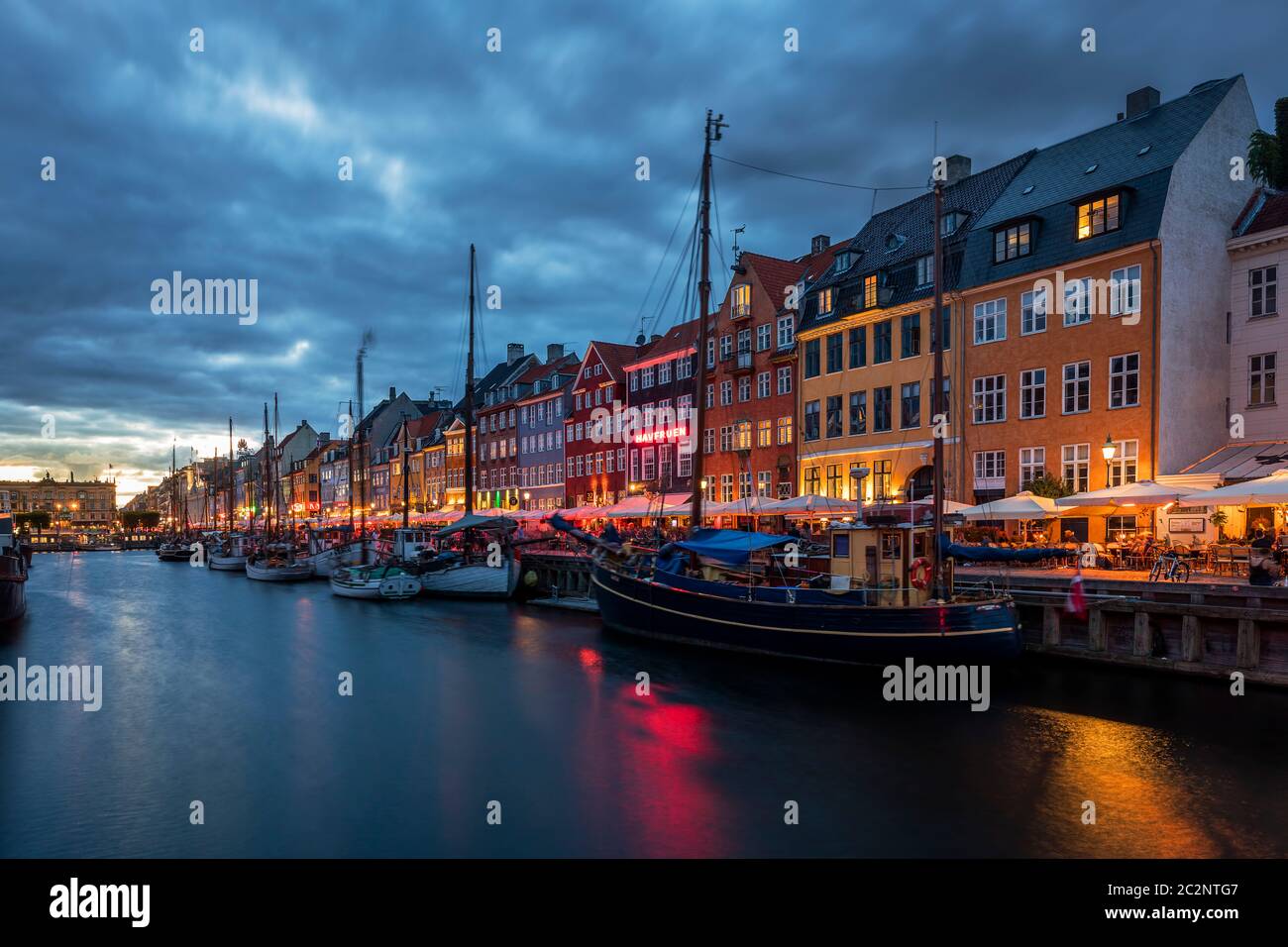 Nyhavn Kanal in Kopenhagen mit den Restaurants bei Sonnenuntergang Stockfoto