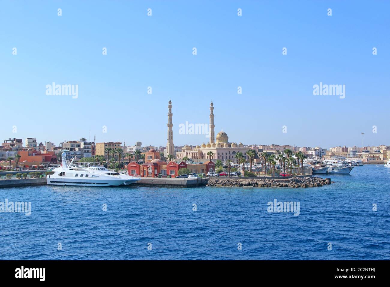 Blick auf den Damm von Hurghada mit festgeschobenen Yachten, Schiffen und einer schönen Moschee Stockfoto