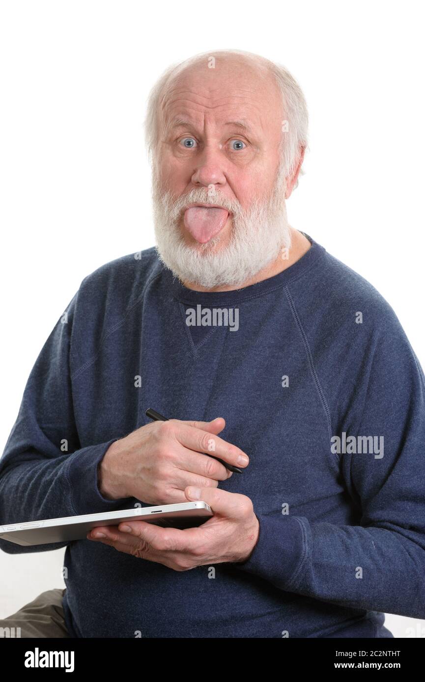 Lustige alte Mann mit herausgestreckter Zunge kleben mit Tablet Computer isoliert auf weißem Stockfoto