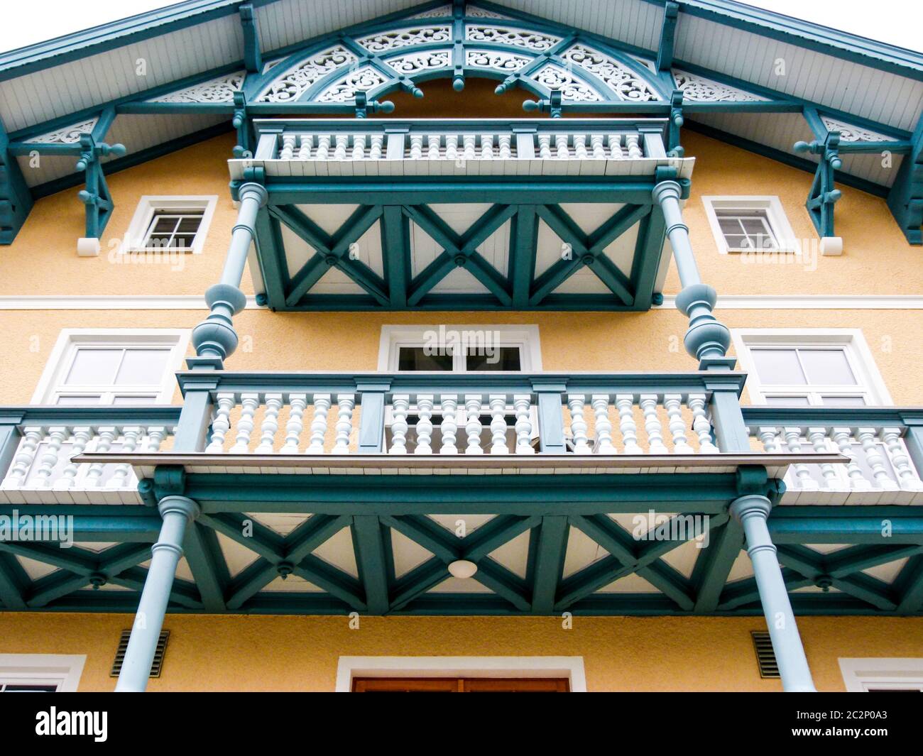 Sehr gepflegtes älteres Gebäude mit Holzbalkons und wunderschönen Dachdekorationen Stockfoto