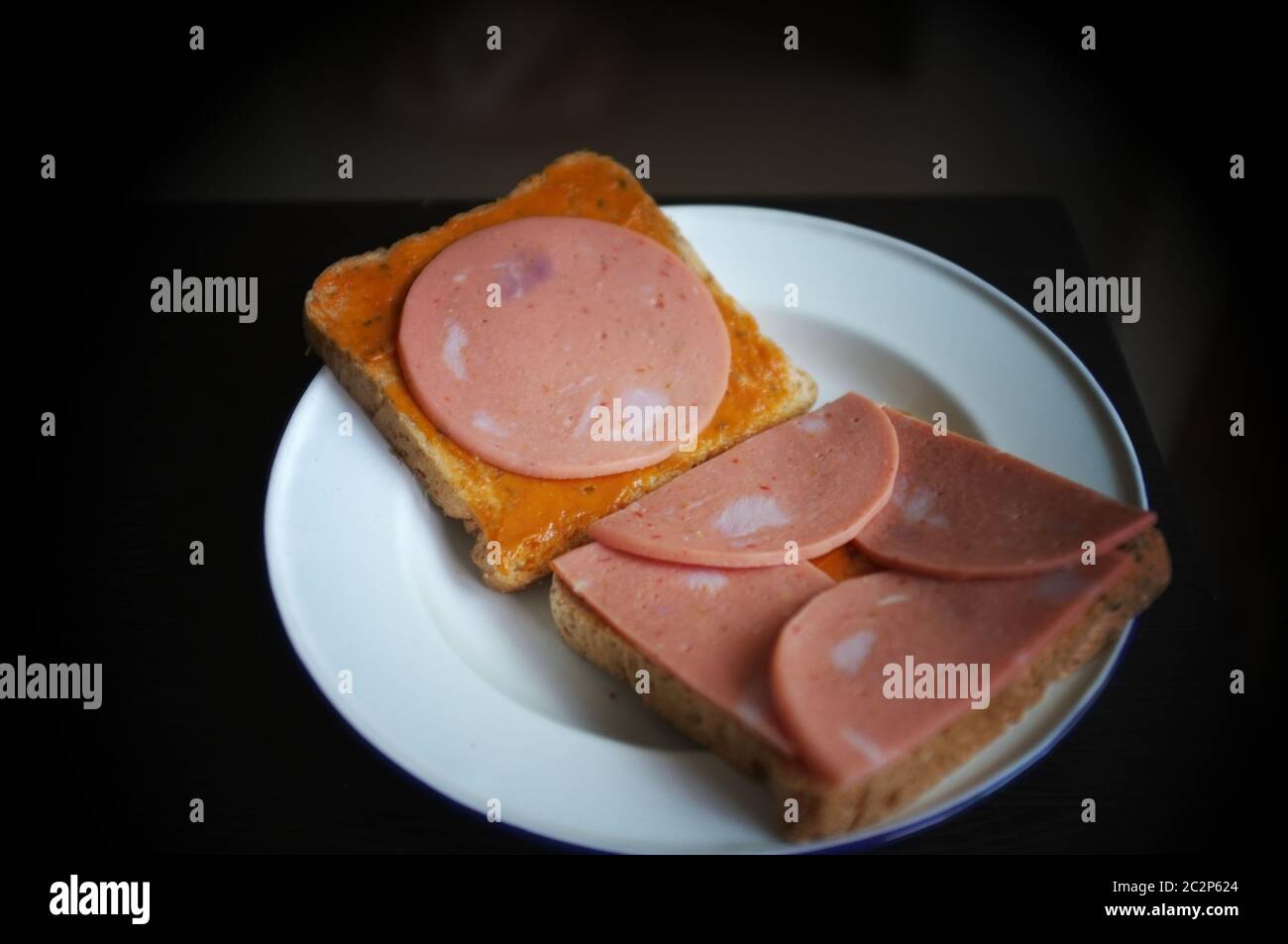 Brot mit Schweinshaxe auf weißer Platte schneiden Stockfoto