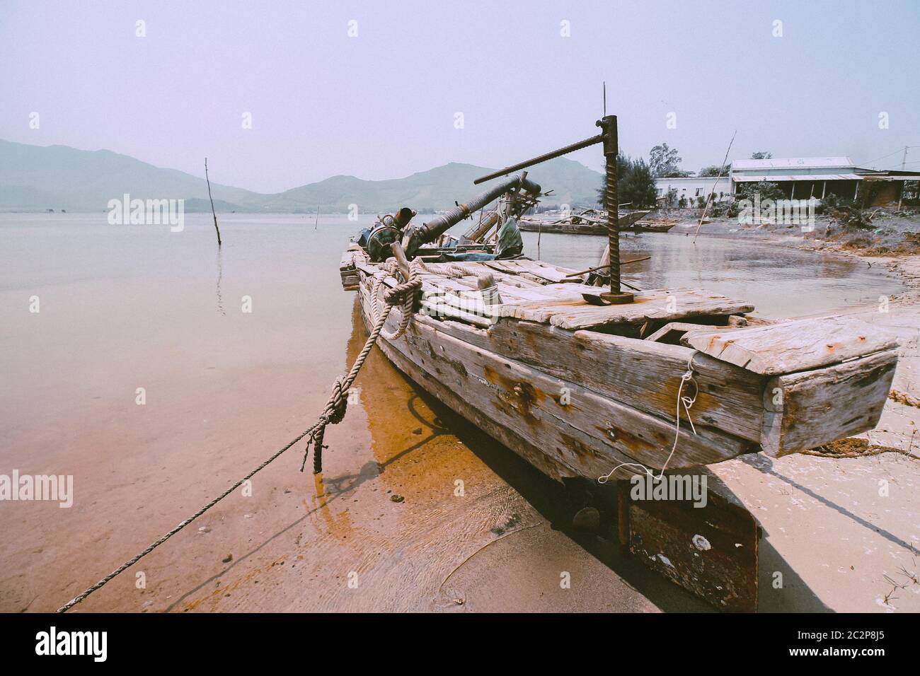 Altes vietnamesisches Holzfischboot in Qhuy nhon Fischerdorf in Vietnam, das die lokale Kultur und Lebensgrundlage zeigt Stockfoto