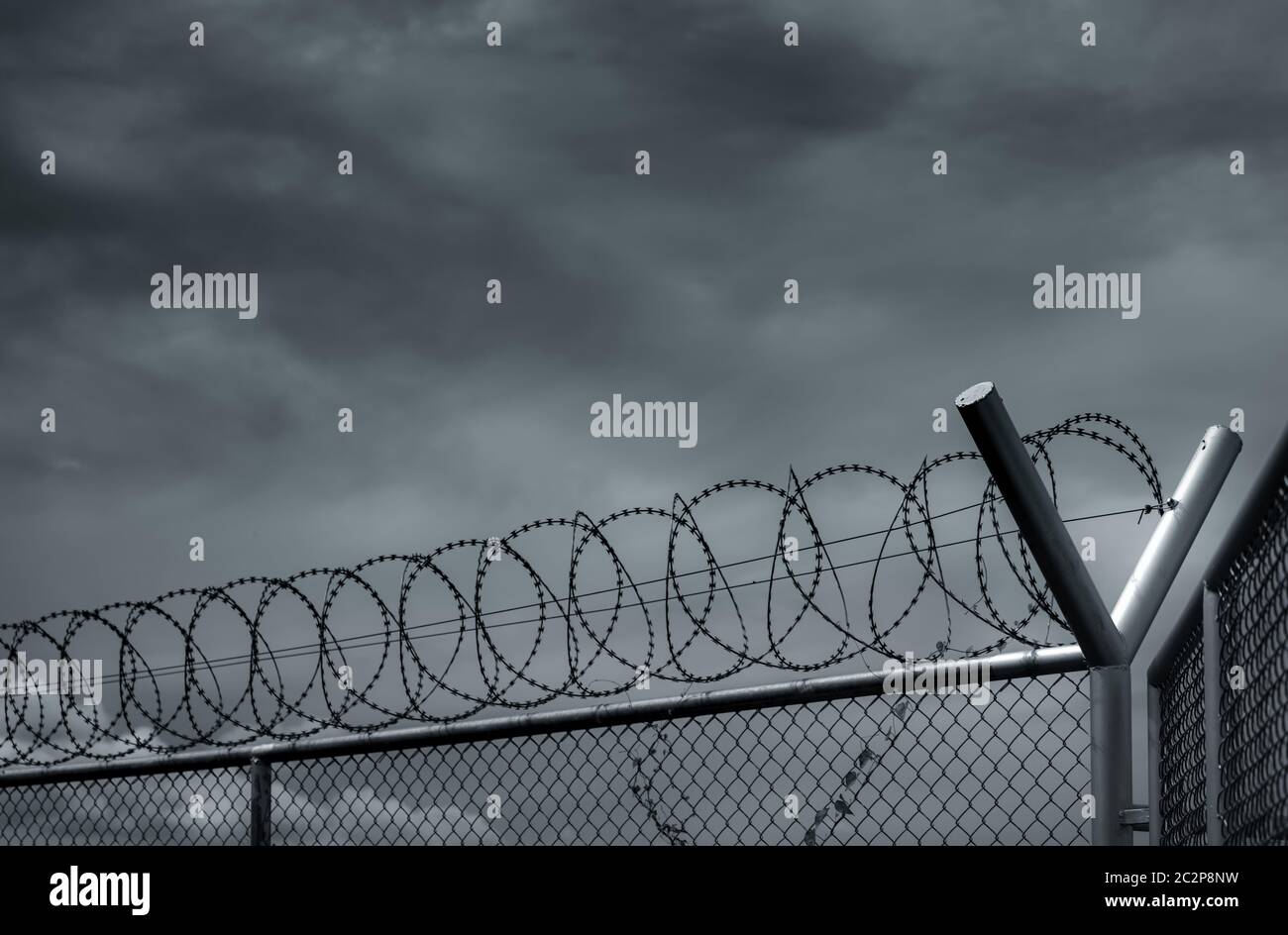 Sicherheitszaun im Gefängnis. Stacheldraht-Sicherheitszaun. Rasiermesserscharfe Gefängnismauer. Barriere Grenze. Sicherheitswand der Grenze. Gefängnis für Festnahme Verbrecher Stockfoto