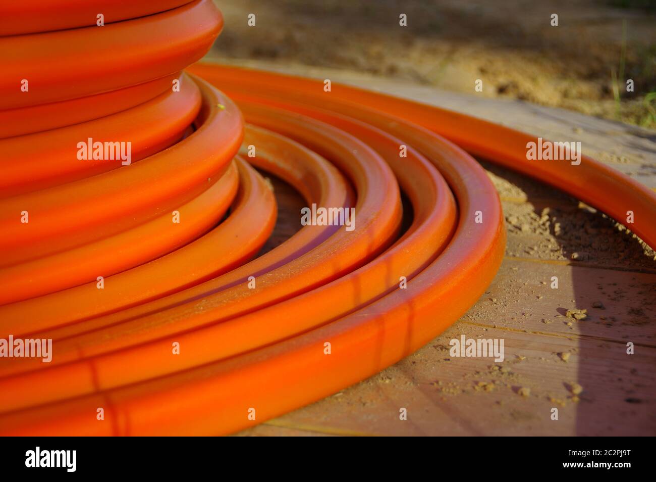 Eine Rolle orangefarbener Kabel. Aufbau der Glasfaserinstallation. Stockfoto