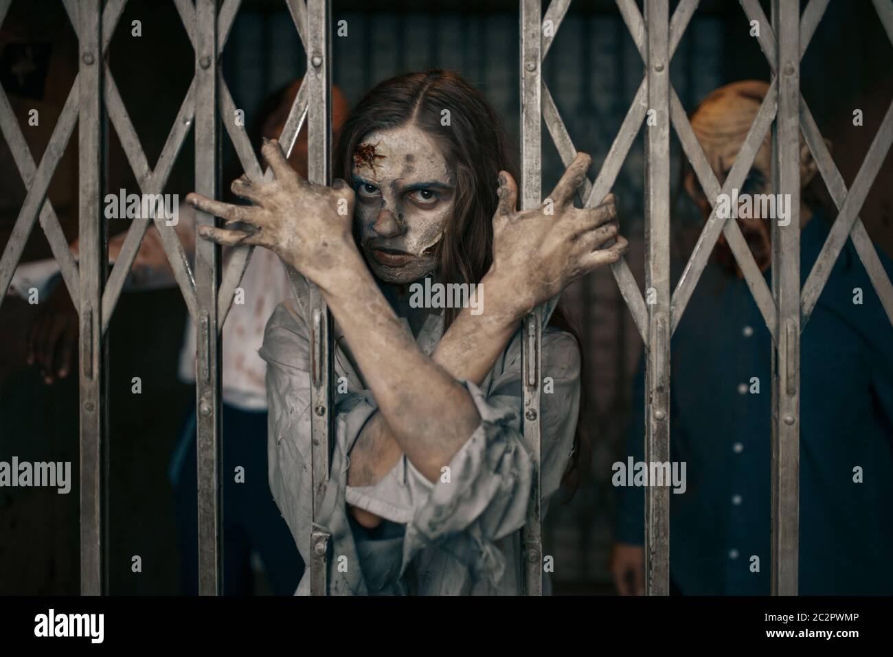 Zombie hinter den Gittern des Aufzugs, Todesfalle, tödliche Verfolgungsjagd. Horror in der Stadt, gruselige Krabbelangriffe, Weltuntergangsapokalypse, blutige Monster Stockfoto