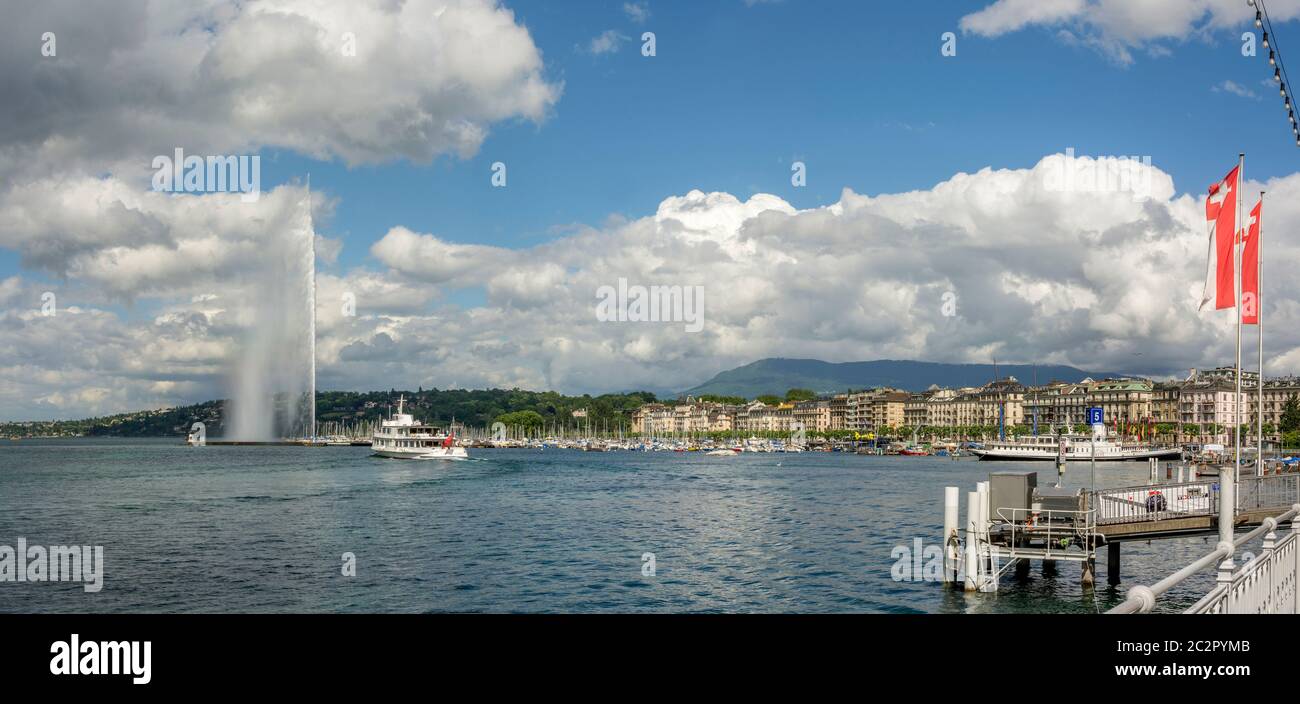 Blick auf den Jet d'Eau Brunnen in Genf mit Booten auf dem See und bewölktem Himmel. Schweiz Stockfoto