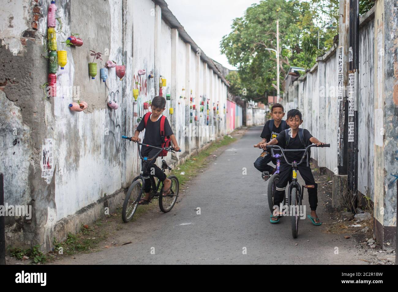 Mataram, Lombok, Indonesien - 21. August 2017: Einheimische Kinder fahren auf der Straße von Mataram, Indonesien, Fahrräder. Stockfoto