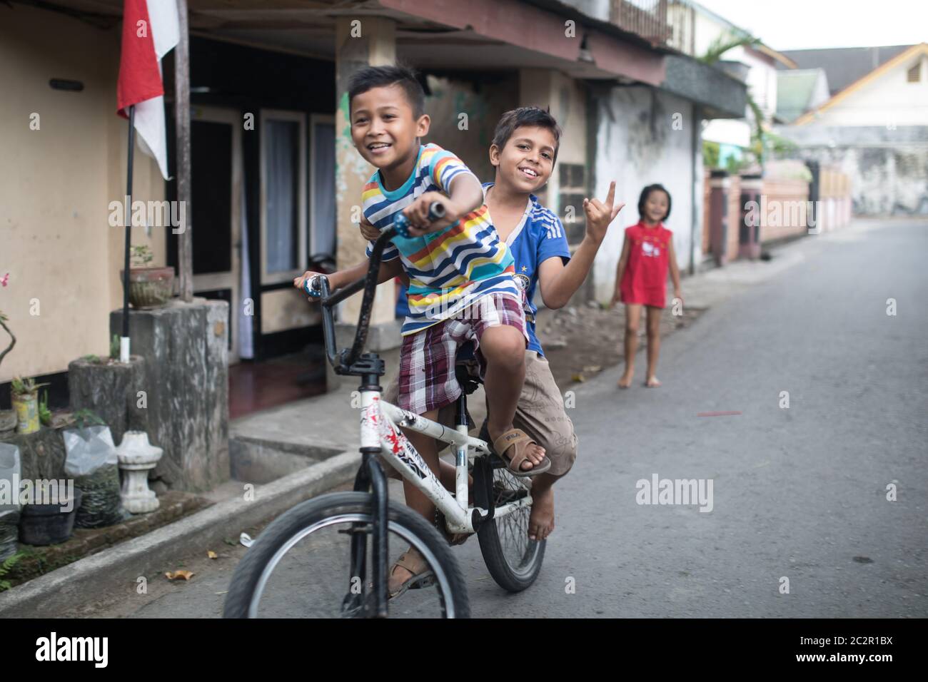 Mataram, Lombok, Indonesien - 21. August 2017: Einheimische Kinder fahren auf der Straße von Mataram, Indonesien, Fahrräder. Stockfoto