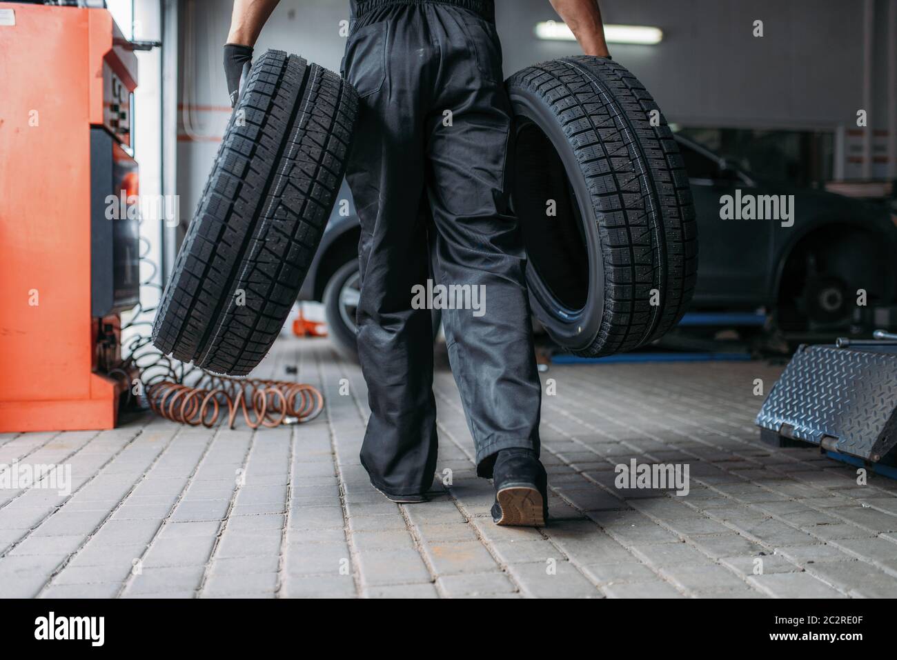 Auto Mechaniker hält zwei neue Reifen, Reparatur-Service. Arbeiter  repariert Autoreifen in der Garage, professionelle Kfz-Inspektion in der  Werkstatt Stockfotografie - Alamy