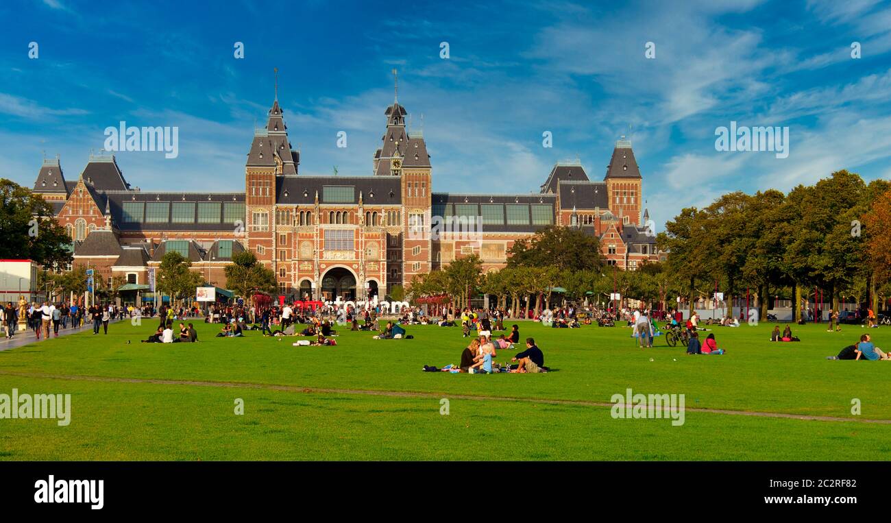 Besucher genießen einen sonnigen Nachmittag auf dem grasbewachsenen Gelände des Rijksmuseums in Amsterdam, Nordholland, Niederlande, Europa Stockfoto