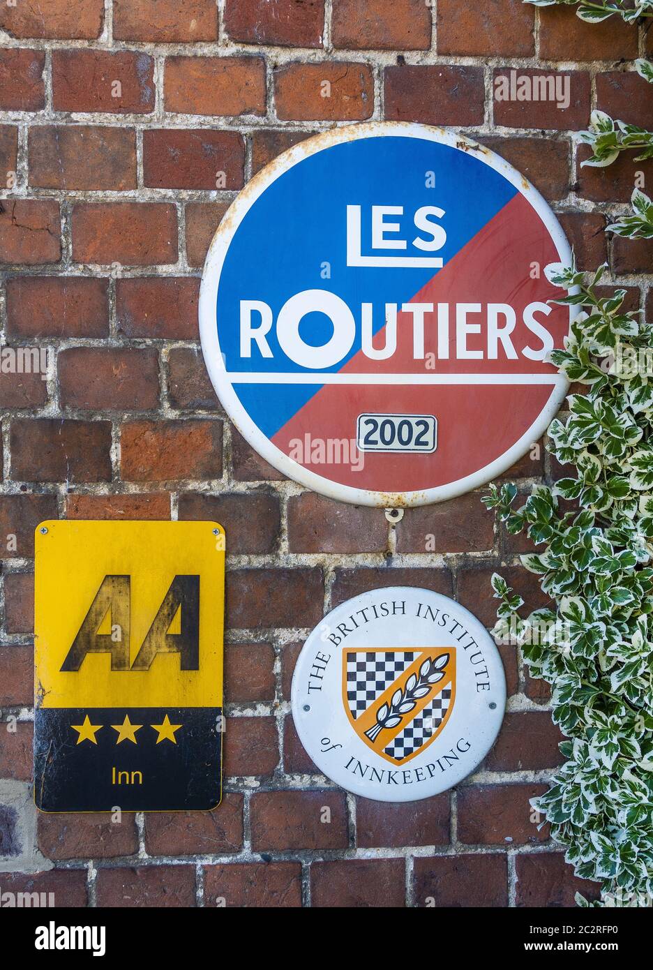 Verkehrsschilder an der White Lion Pub Wall in Wherwell, Hampshire, England, Großbritannien Stockfoto