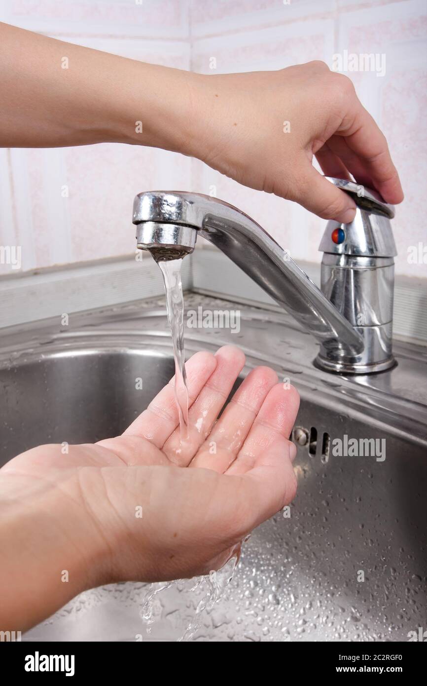 Frauen Hand öffnen Wasserhahn Stockfoto