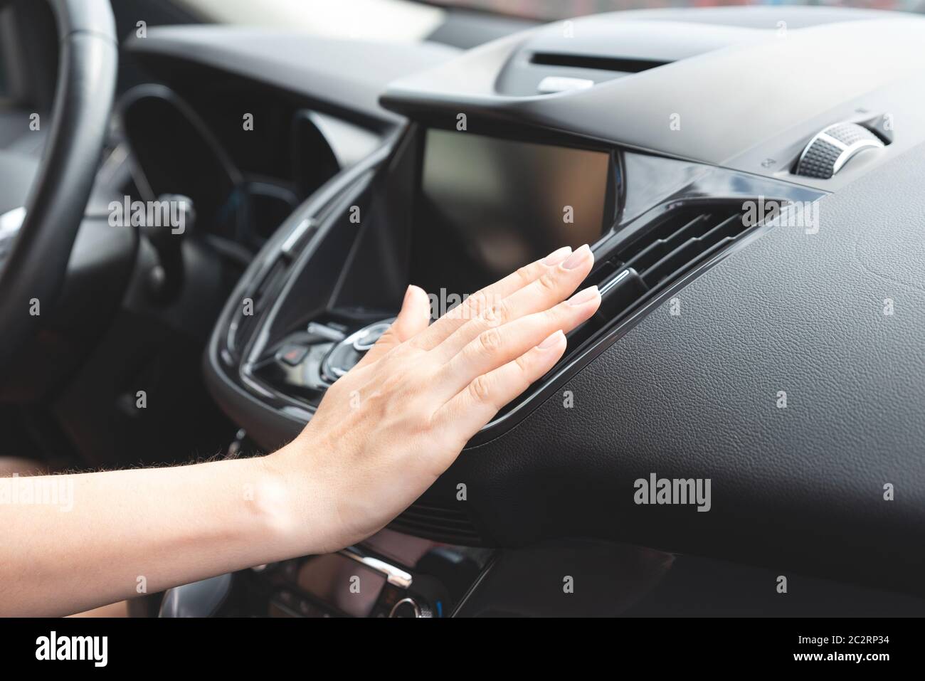 Klimaanlage für Autos. Frau überprüft die Klimaanlage in einem Auto Stockfoto