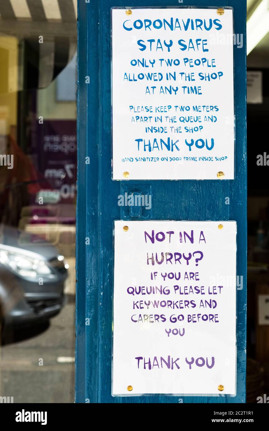 Schilder vor einem Gemüsehändler in Presteigne, Wales, UKF, beschränken die Kundenzahlen und geben Schlüsselarbeitern während der Pandemie den Vorzug Stockfoto
