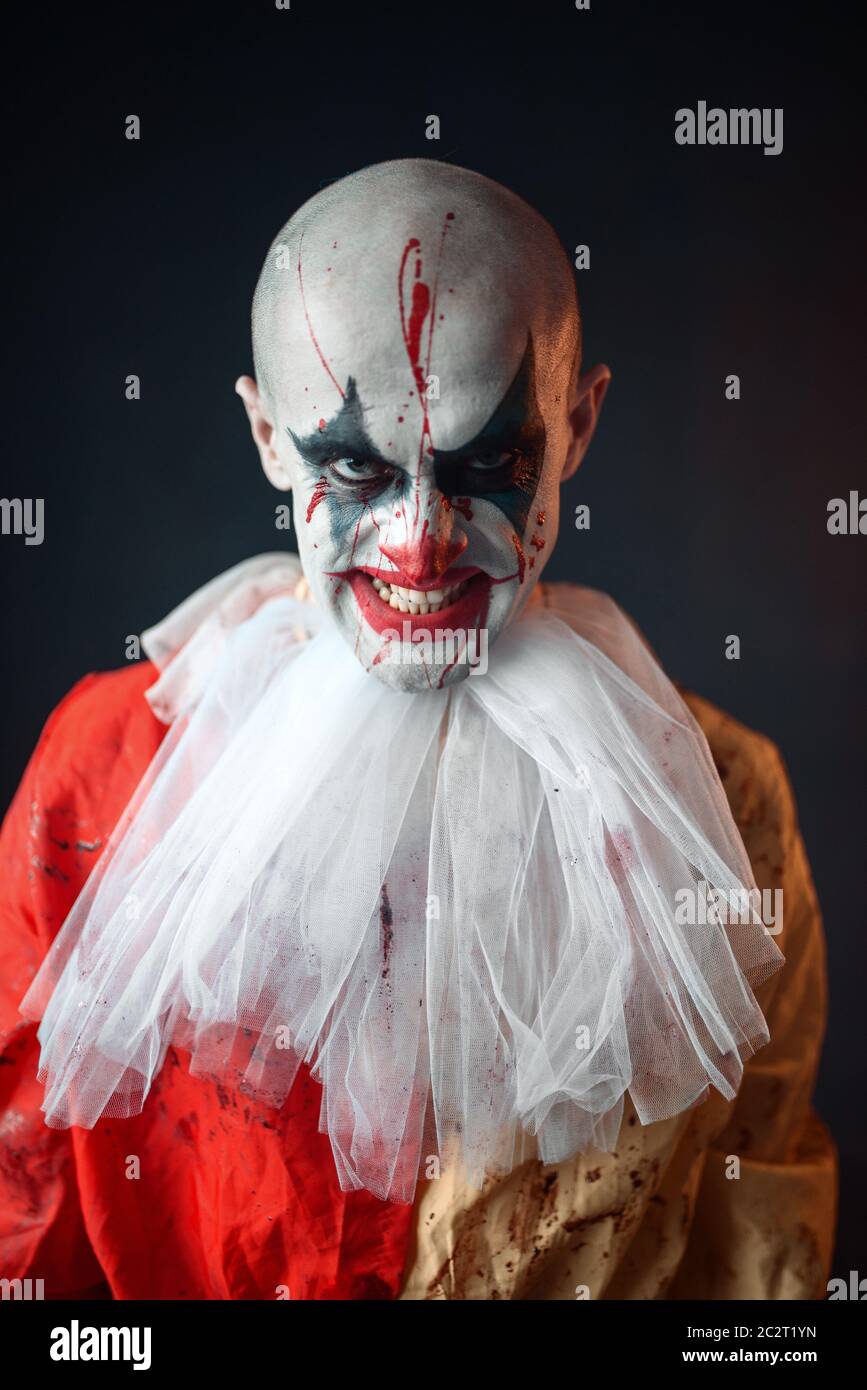 Portrait von Mad bloody Clown, Gesicht im Blut. Mann mit Make-up im Halloween Kostüm Stockfoto