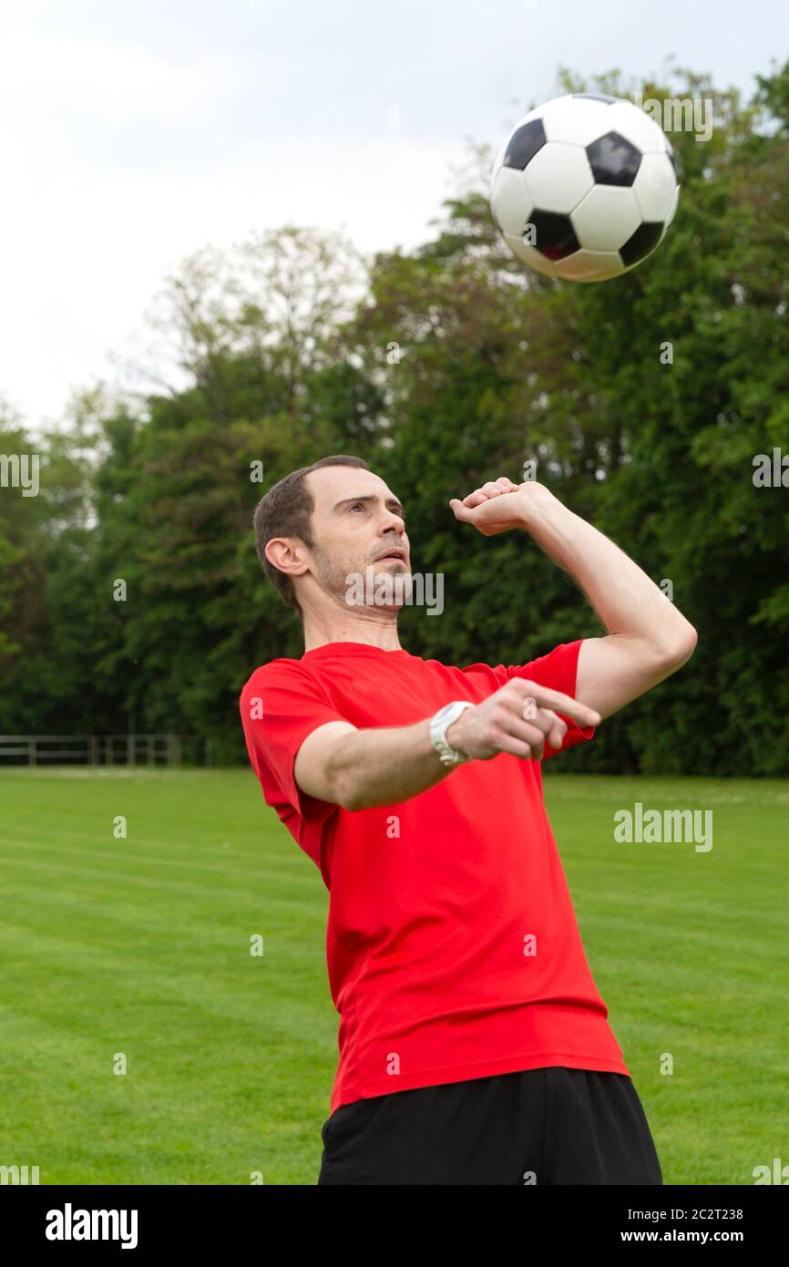 Junge Mann spielt Fußball auf einem Fußballfeld Stockfoto