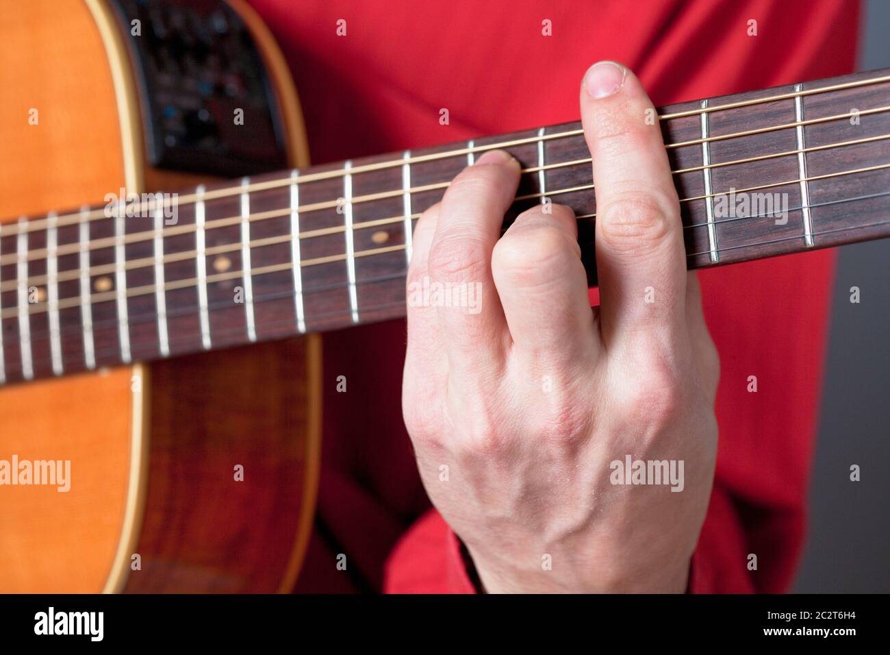 Finger eines Gitarristen, der akustische Gitarre spielt. Stockfoto