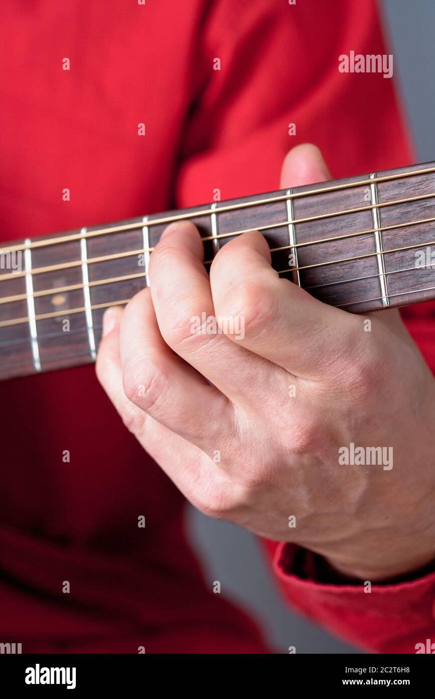 Finger eines Gitarristen, der akustische Gitarre spielt. Stockfoto