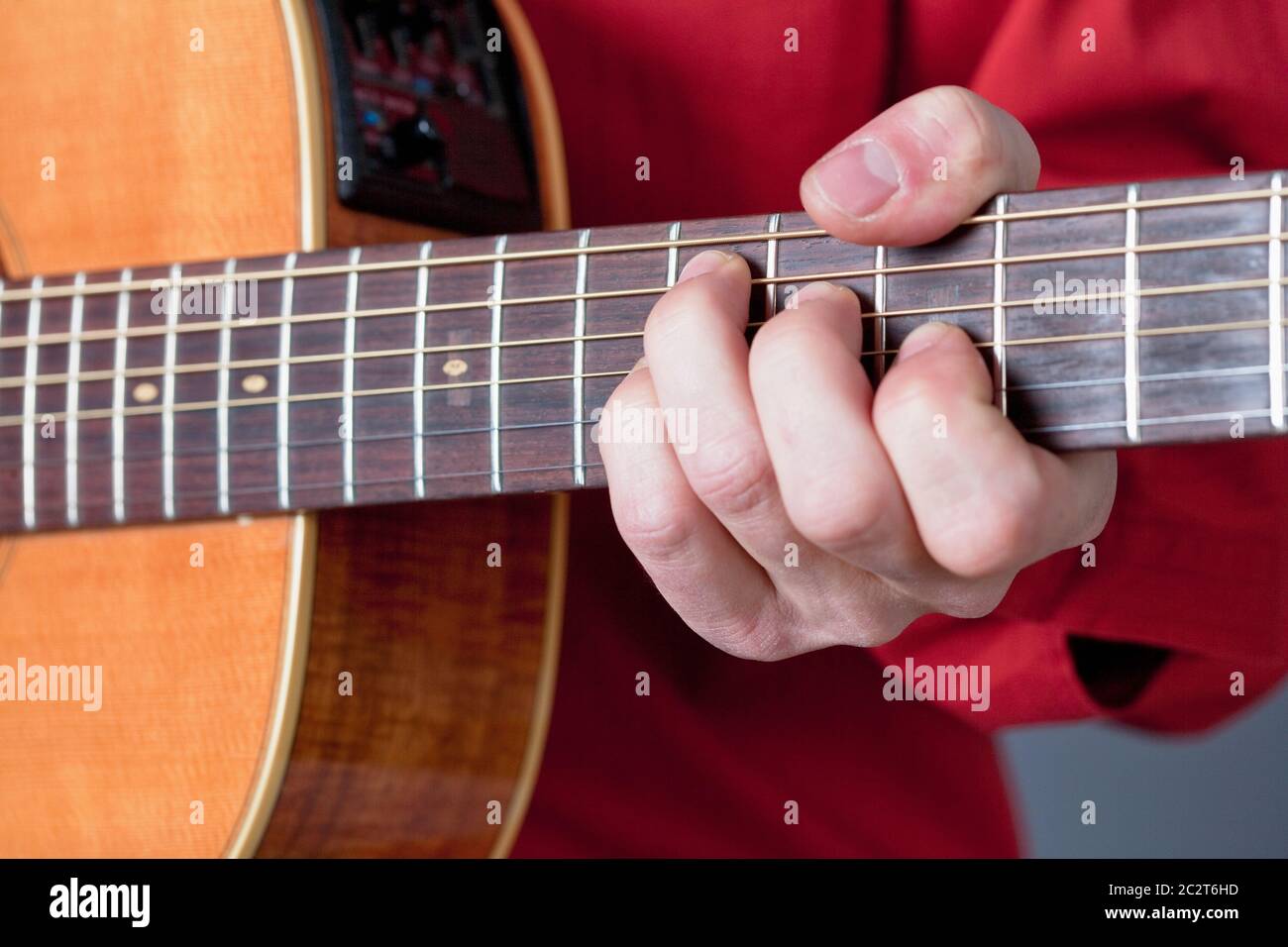 Finger eines Gitarristen, der akustische Gitarre spielt. Stockfoto