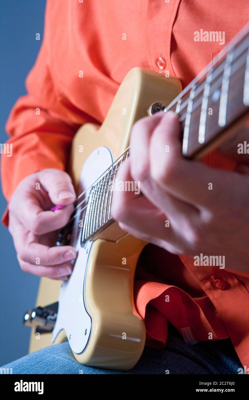Finger eines Gitarristen, der E-Gitarre spielt. Stockfoto