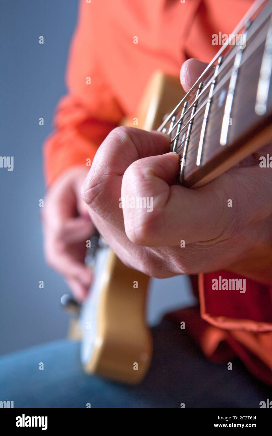 Finger eines Gitarristen, der E-Gitarre spielt. Stockfoto