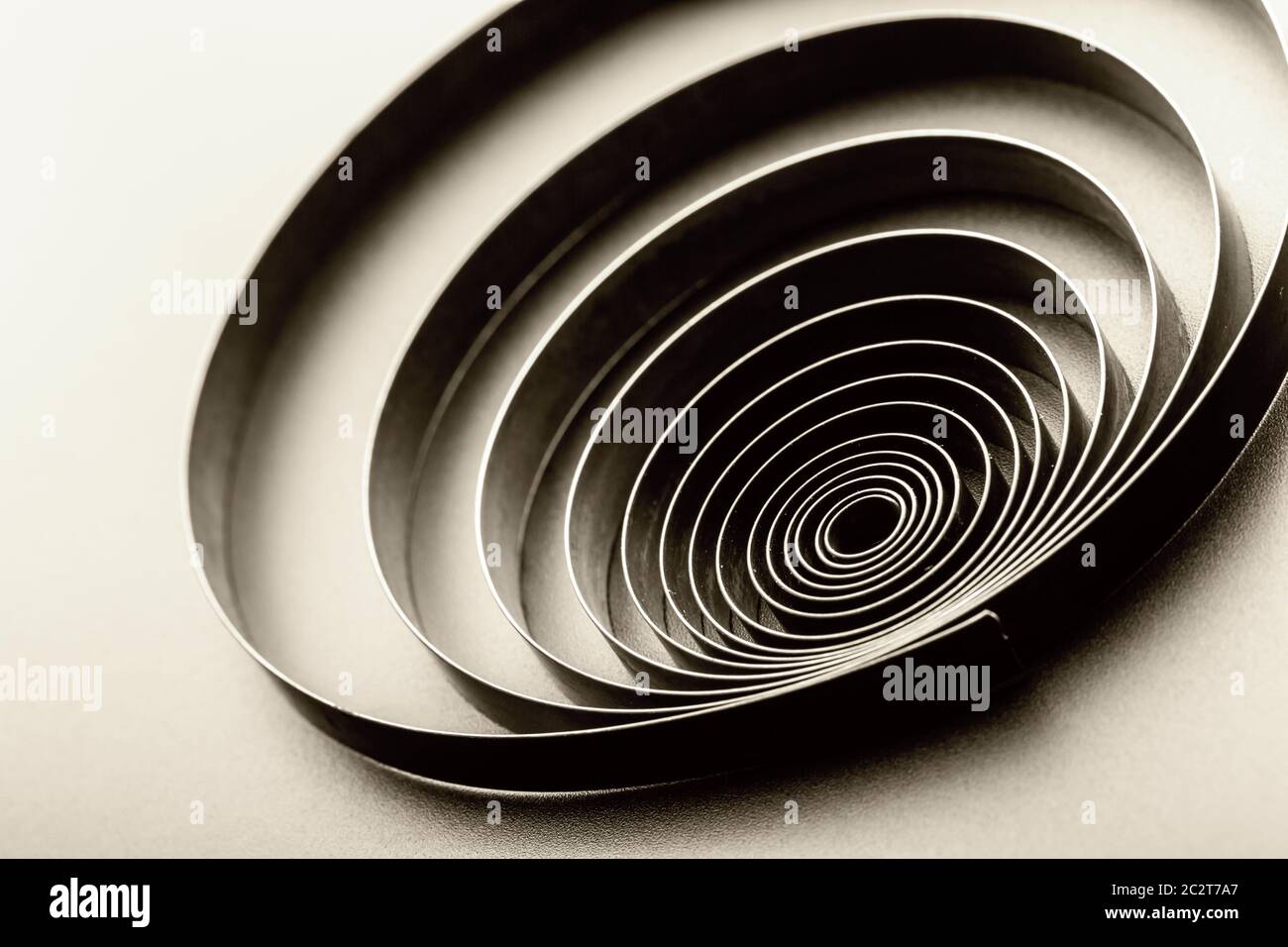 Abstrakte metallische Feder auf grauem Hintergrund. Getönten Stockfoto