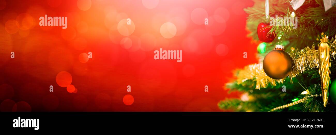 Geschmückter Weihnachtsbaum auf rot leuchtendem Hintergrund Stockfoto