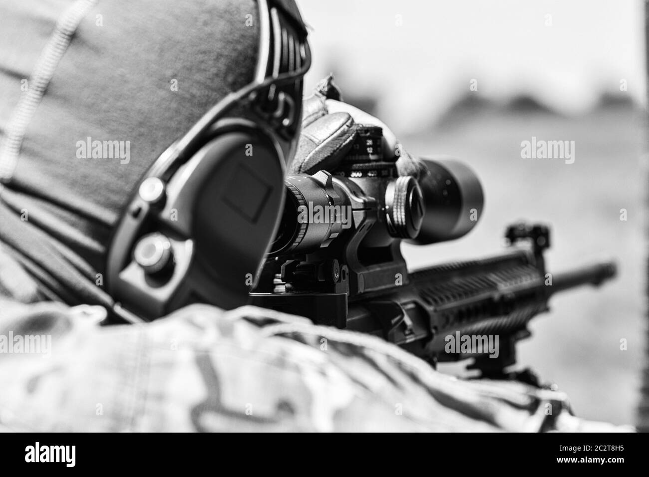 Militärmann in Tarnuniform mit Gewehr. Ausgerüstet Scharfschützenschießen mit Gewehr. Stockfoto