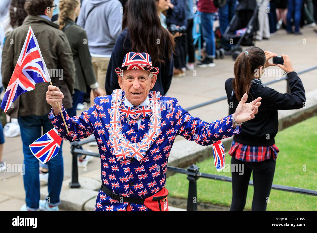 Ein königlicher Fan im Union Jack Outfit und Flaggen feiert bei der Trooping the Color Parade in London, England, Großbritannien Stockfoto