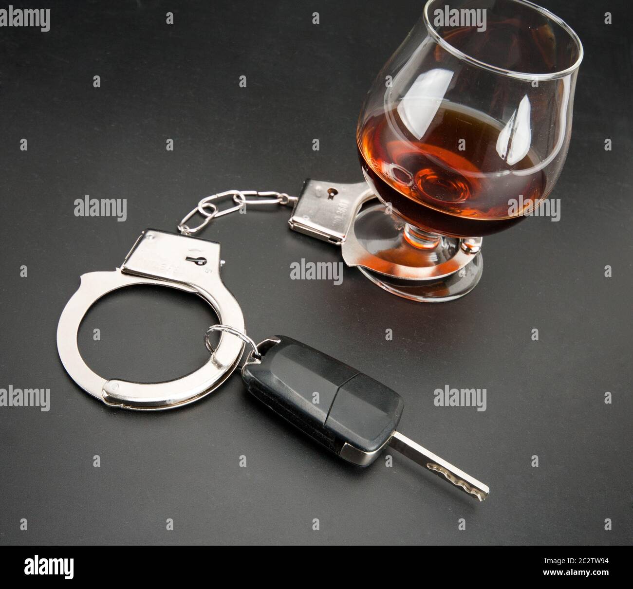 Autoschlüssel von Handschellen, Glas Alkohol gesperrt. Stockfoto