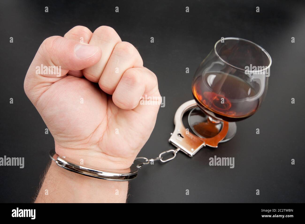 Eine Hand von Handschellen, Glas Alkohol gesperrt. Stockfoto