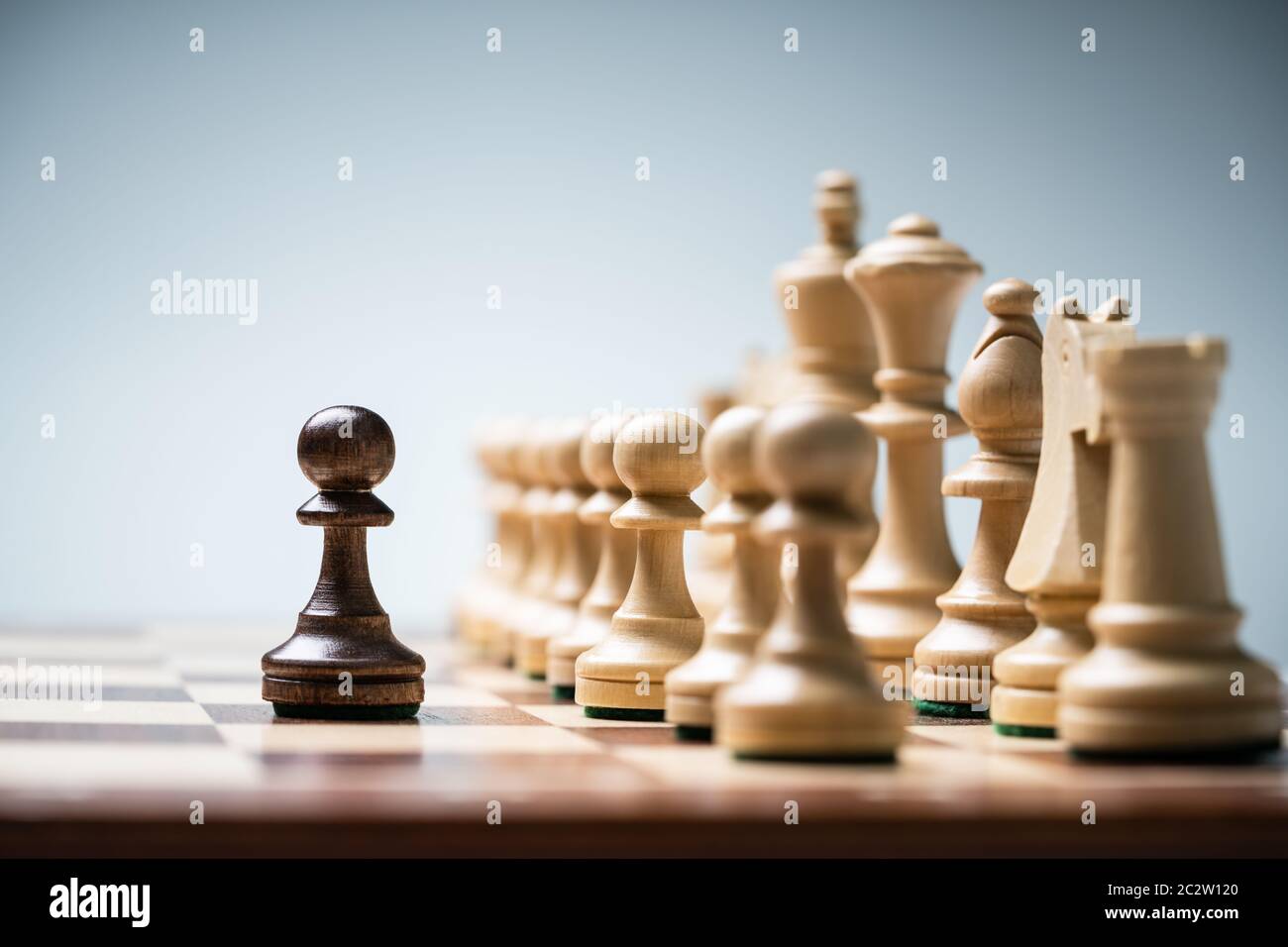 Reihe der Schachfiguren an Bord vor blauem Hintergrund Stockfoto