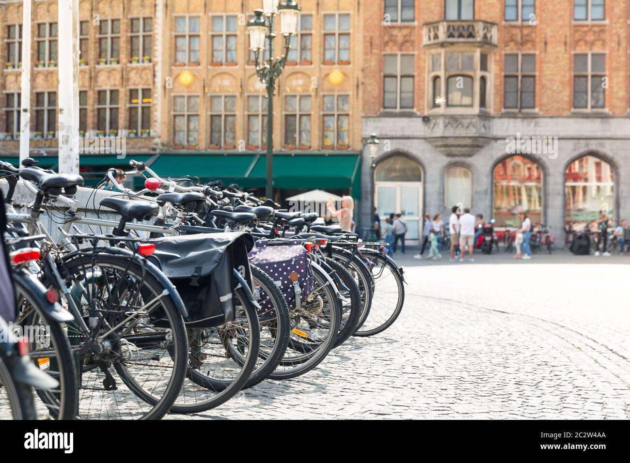 Fahrräder auf dem Platz, Leute im Straßencafé im Hintergrund, alte europäische Touristenstadt. Sommer Tourismus und Reisen, berühmte europa Wahrzeichen, beliebt pl Stockfoto