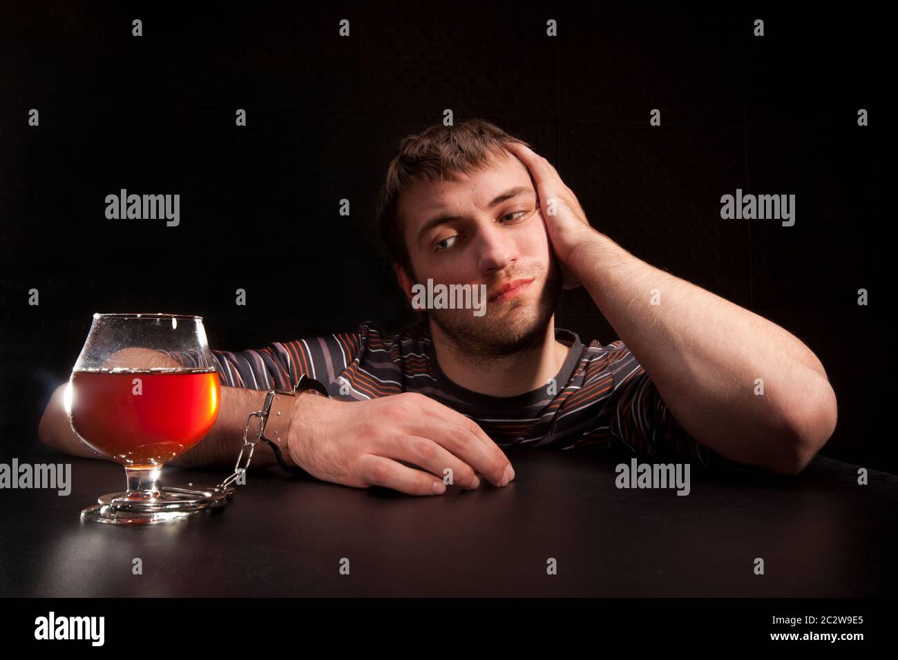 Mann, Glas Alkohol durch Handschellen gesperrt Stockfoto