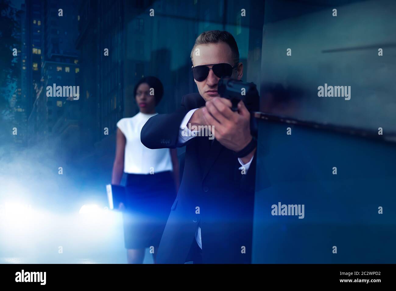 Leibwächter in Anzug und Sonnenbrille mit einer Pistole in der Hand weiblich VIP-Client zu schützen. Security Guard ist eine riskante Beruf, professionelle Guarding, busine Stockfoto