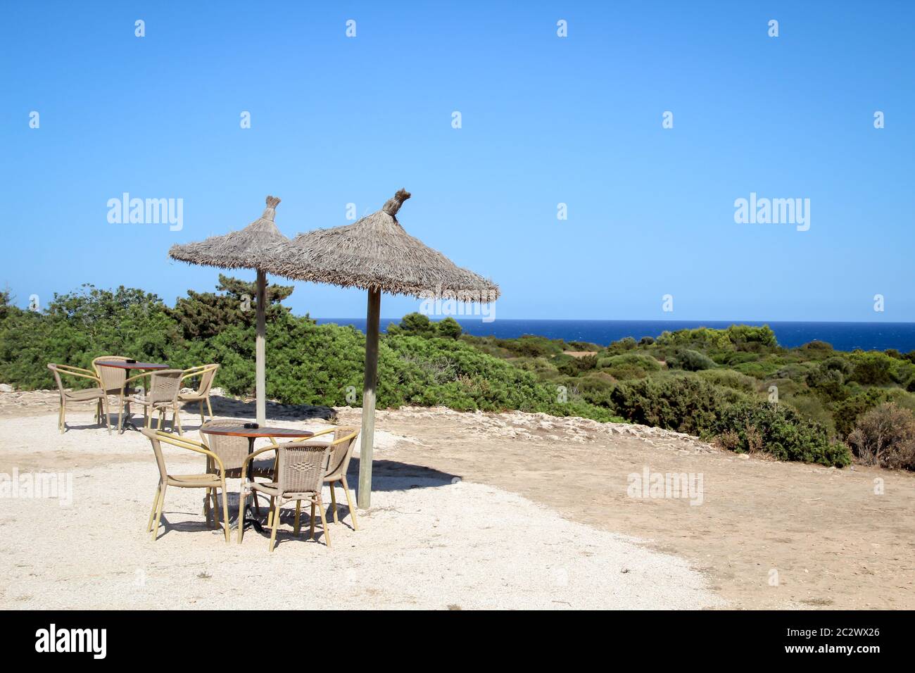 Eine Strandbar mit Strohschirmen und Tischen über den Klippen Stockfoto