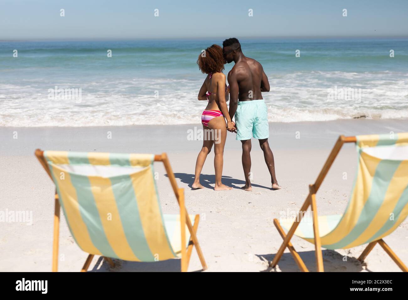 Gemischtes Rennen Paar küssen am Strand Stockfoto