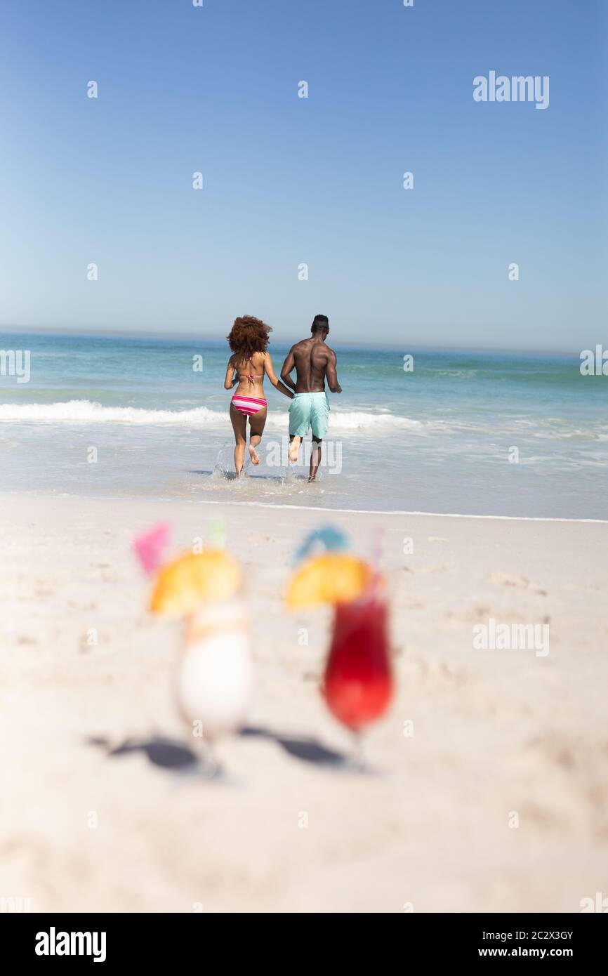 Gemischtes Rennpaar läuft zum Meer Stockfoto