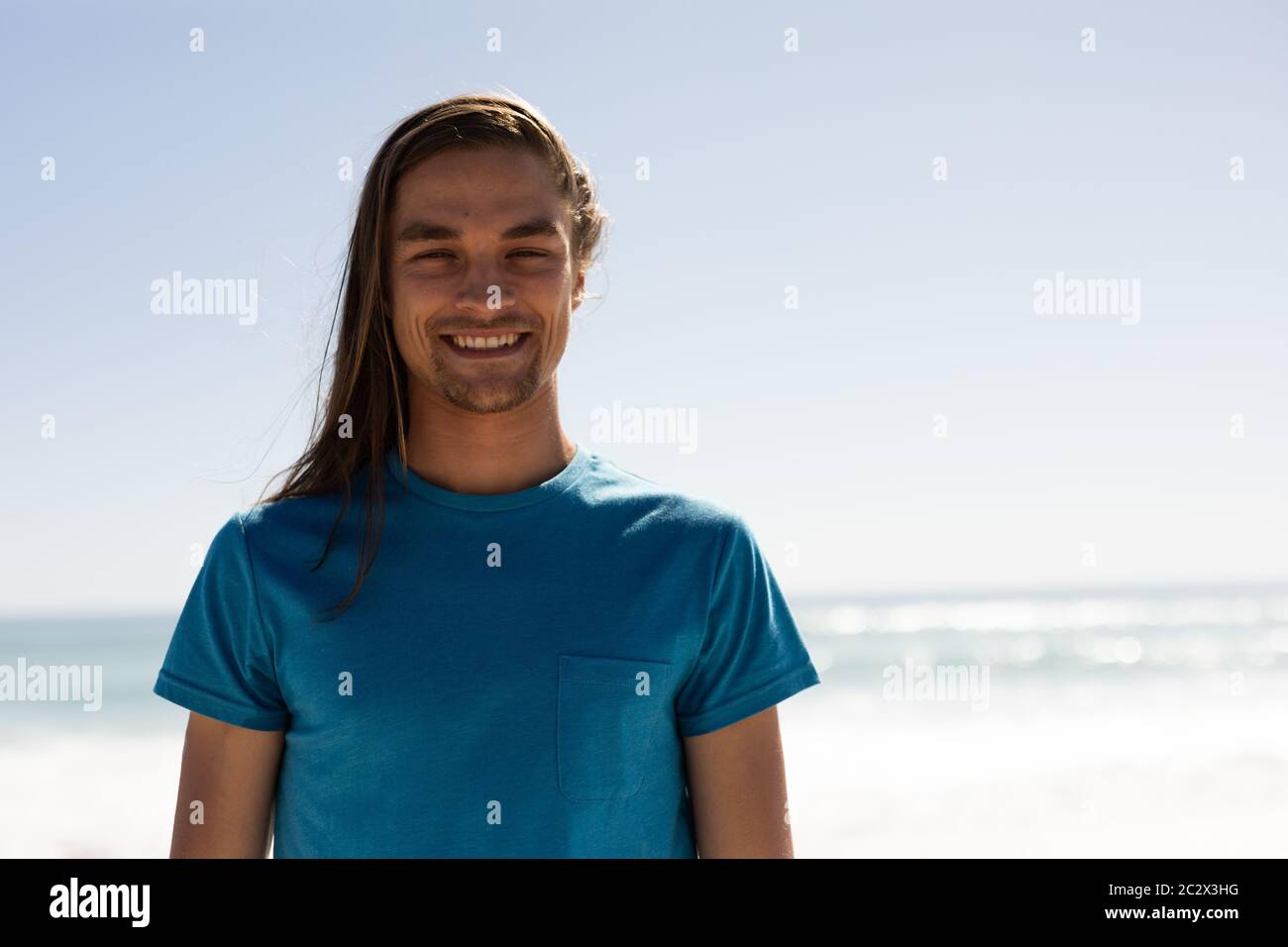 Junger Kaukasischer lächelt am Strand Stockfoto