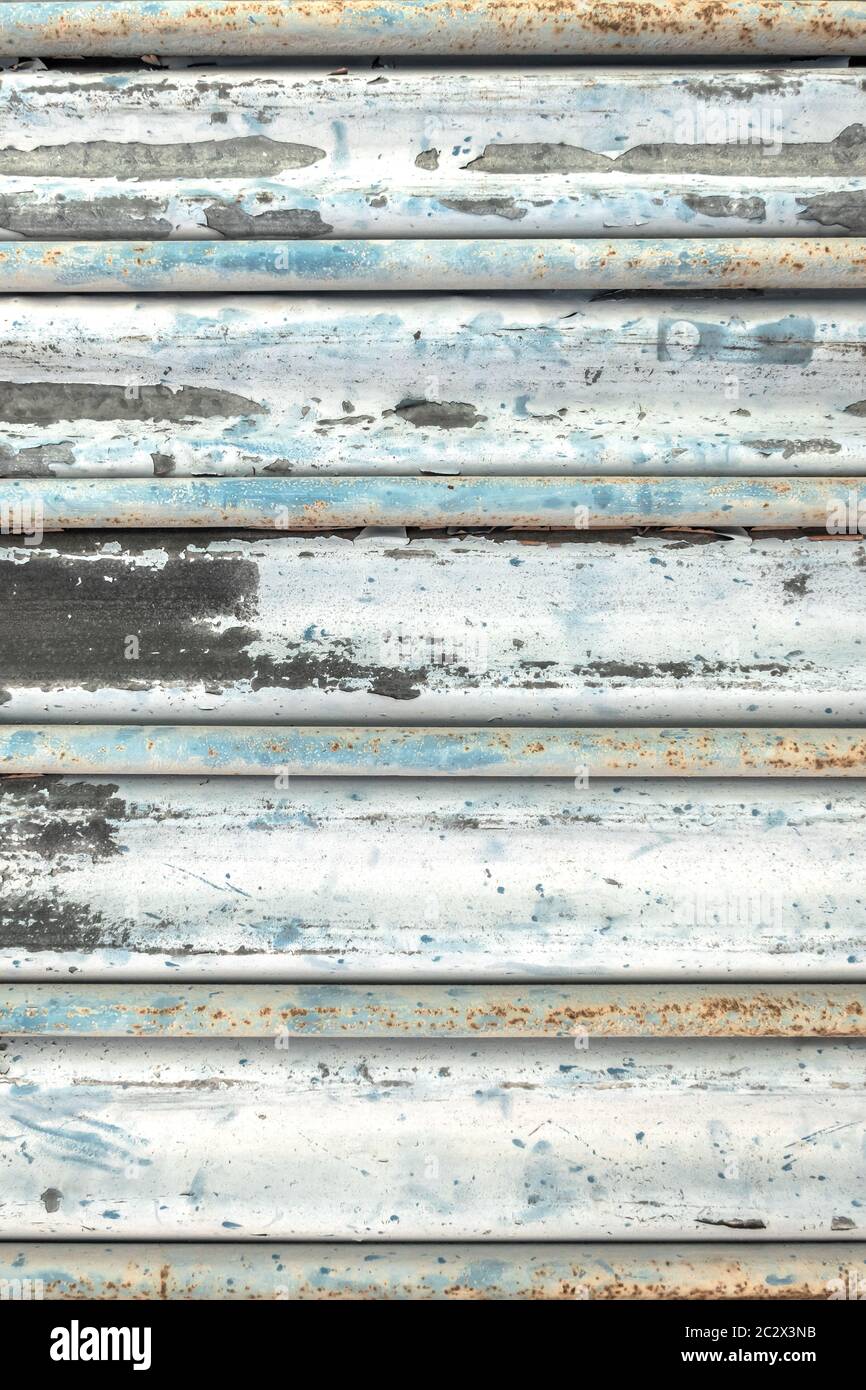 Metall Rollläden Tür mit abblätternder Farbe verschmutzt azurblauen Farbton lackiert. Grunge Hintergrund Textur. Stockfoto