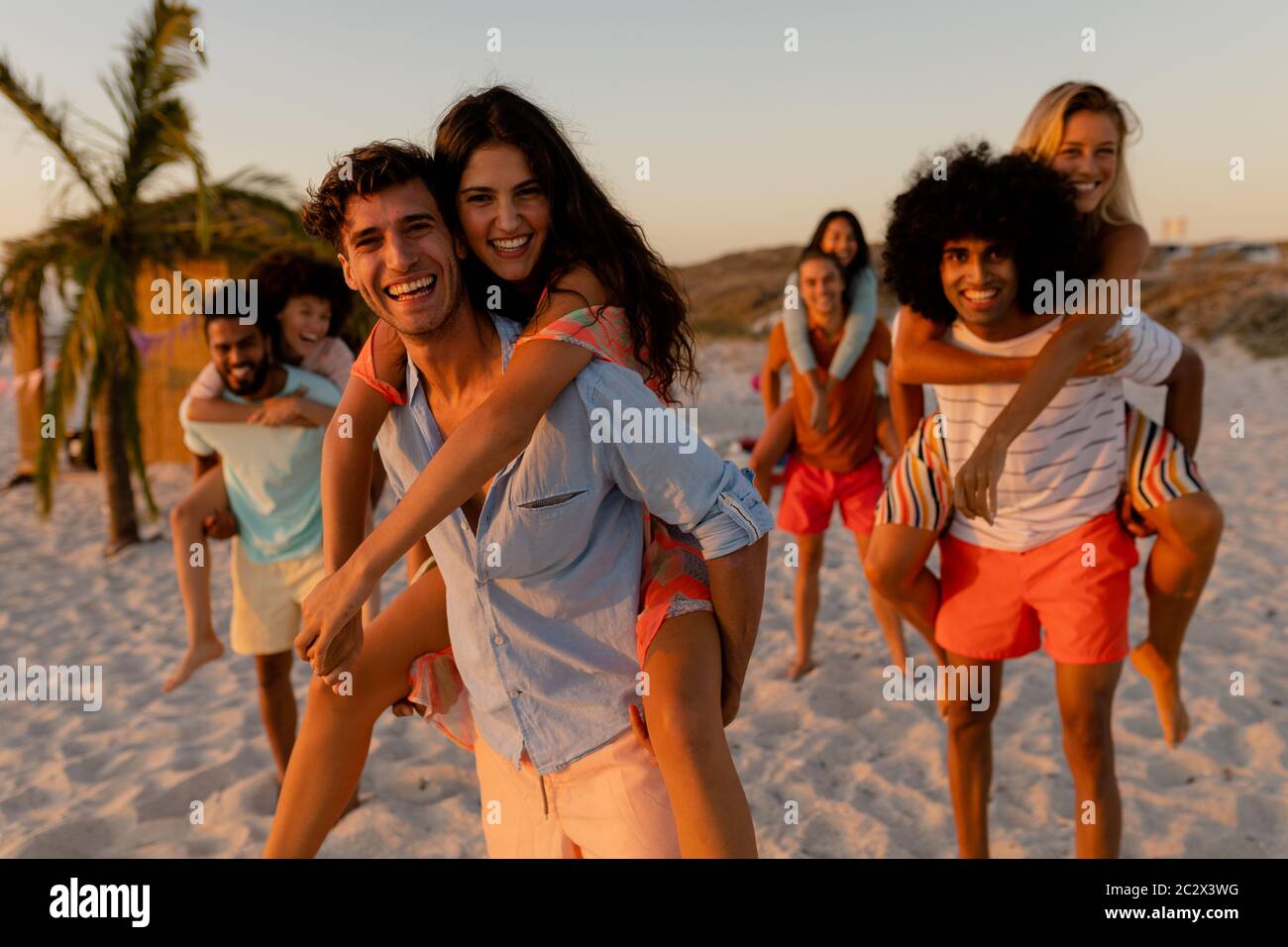 Gemischte Rennfreunde, die Spaß am Strand haben Stockfoto