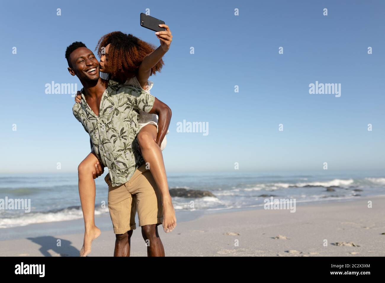 Glückliches Paar unter einem Selfie am Strand Stockfoto