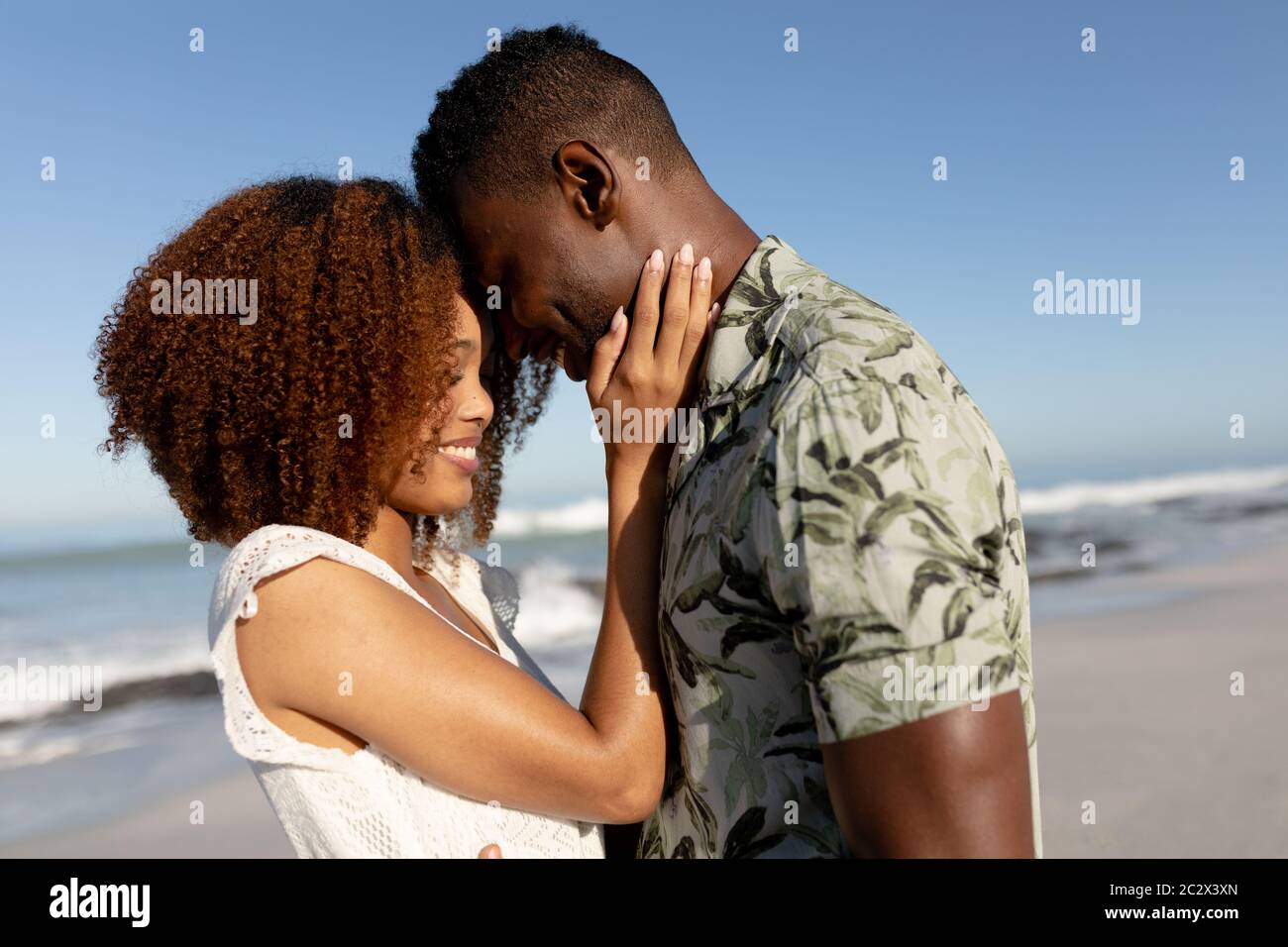 Glückliches Paar umarmen einander am Strand Stockfoto