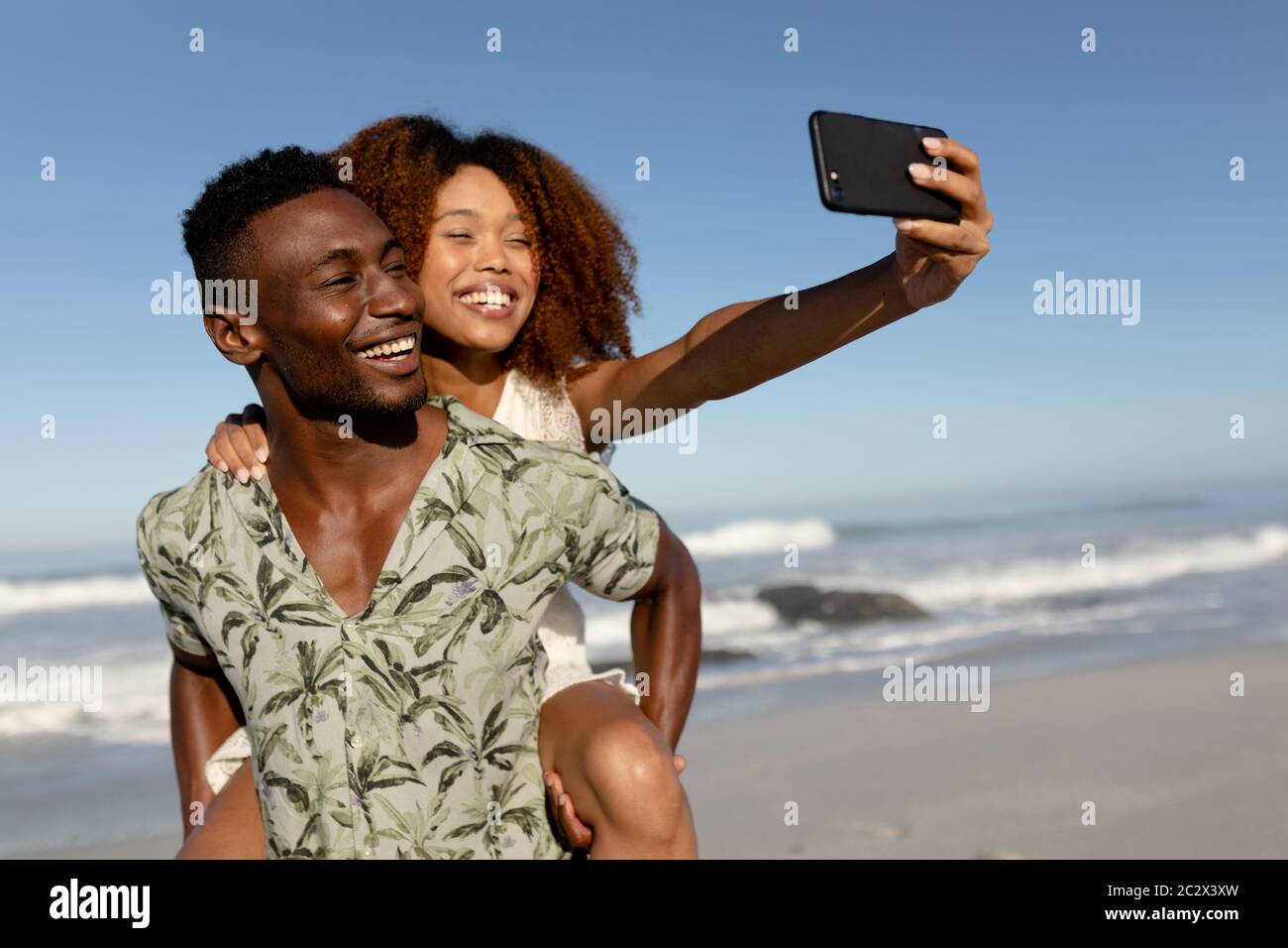 Glückliches Paar unter einem Selfie am Strand Stockfoto