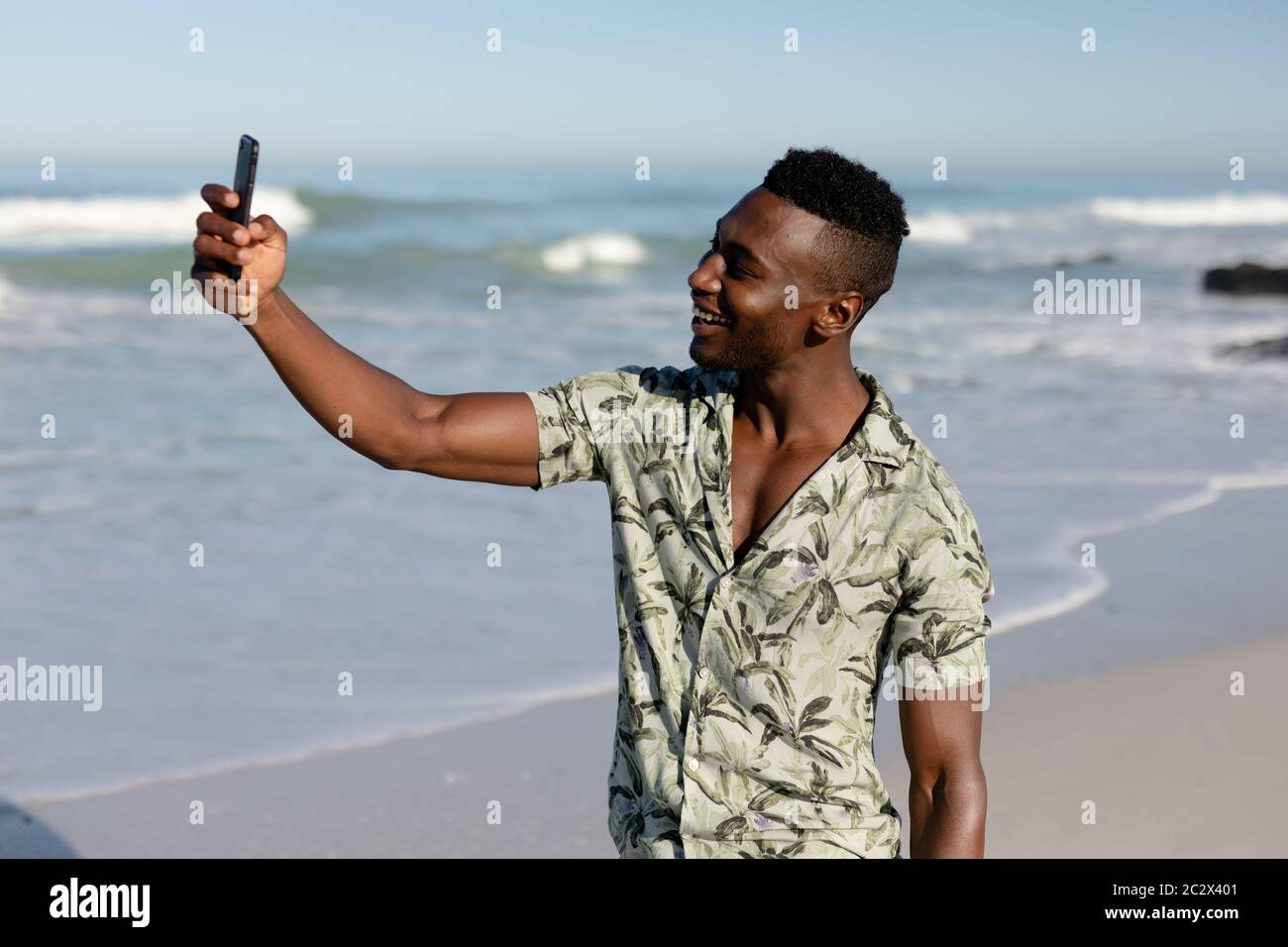 afroamerikanischer Mann, der ein Selfie am Strand nimmt Stockfoto